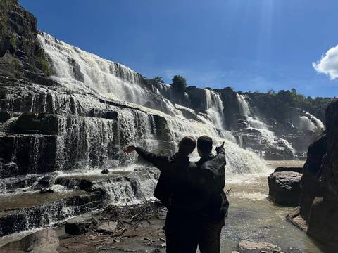       Two people admiring a large waterfall.
  