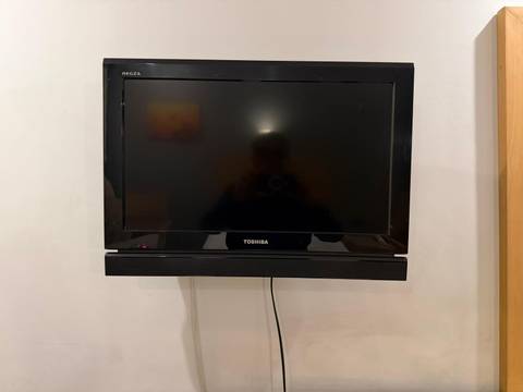       Black flat-screen TV mounted on a wall in a hotel room.
  