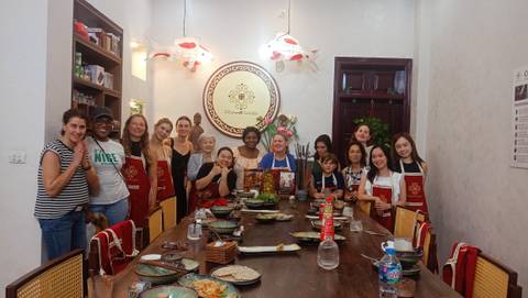 Group of people smiling during a cooking class, posing for the camera.