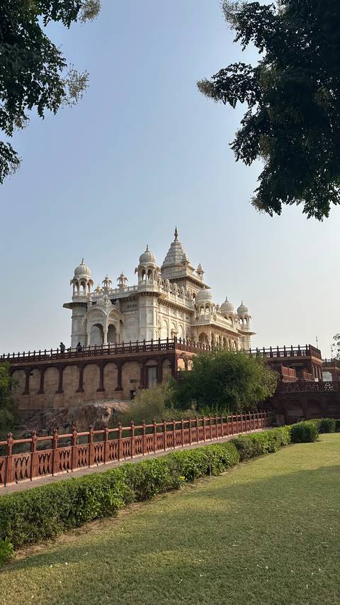 A beautiful white marble building with domed roofs and a large veranda.