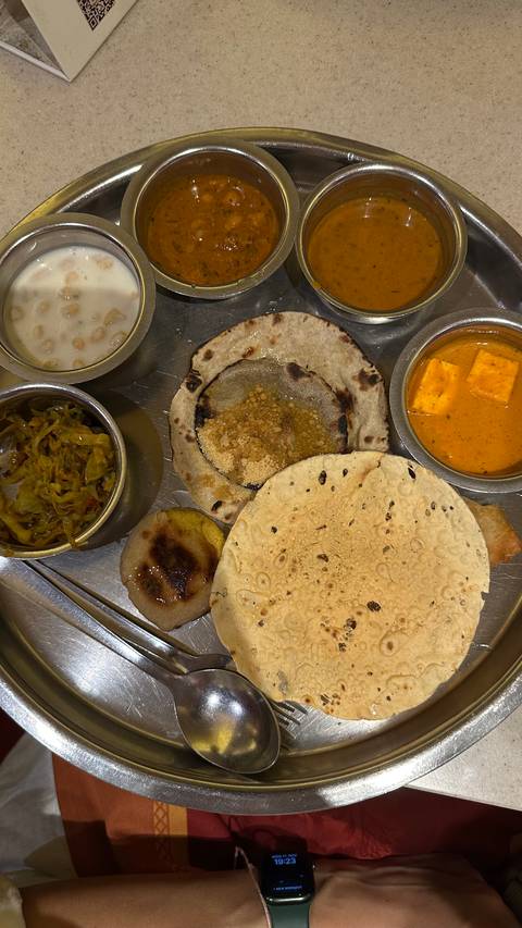 An assortment of traditional Indian dishes including curries and bread.
