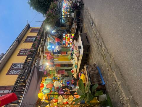 A vibrant lantern shop on a street at dusk in a traditional setting.