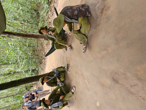 Group of soldiers resting in a forest area.