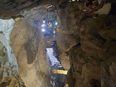 Interior of a large cave with rock formations.