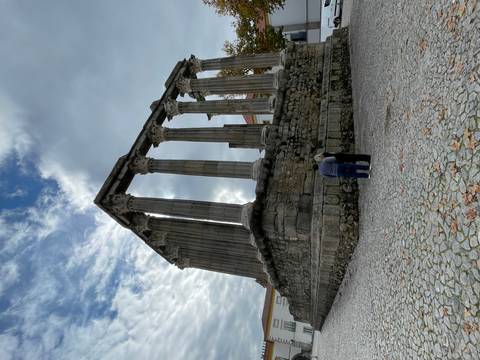 Ancient stone ruins with two people standing at the base.