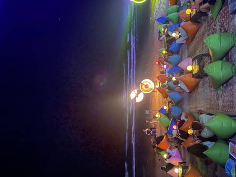 Fire show on the beach with people watching.