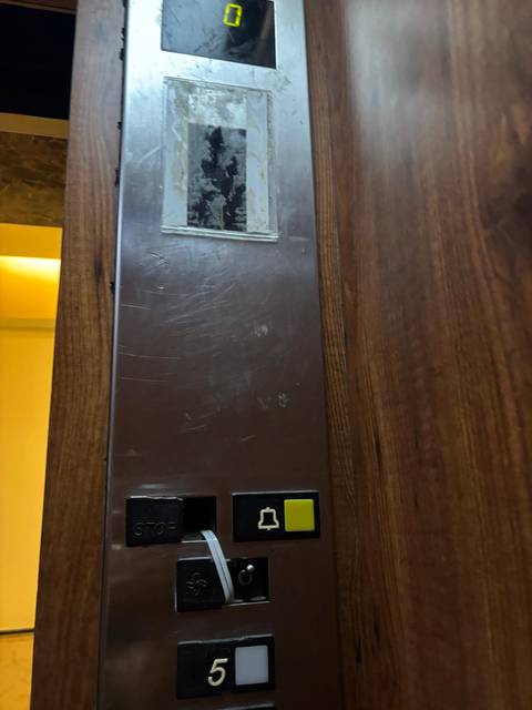 Elevator button panel with scratches.
