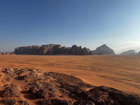       Desert landscape with rocky formations under a clear sky.
  
