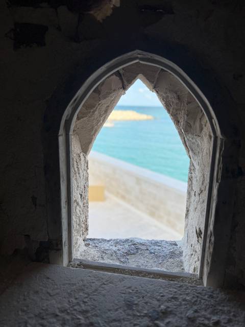 View of the sea through a stone archway.