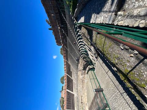 Amphitheater ruins with tiered seating and blue sky.