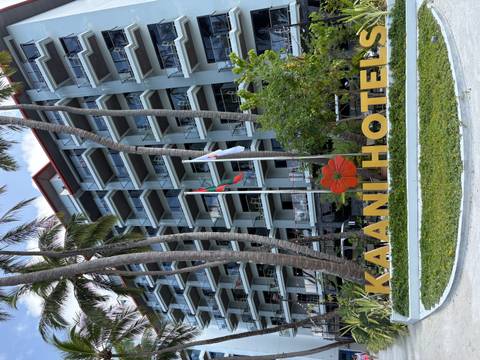       Exterior view of Kaani Hotel surrounded by palm trees.
  