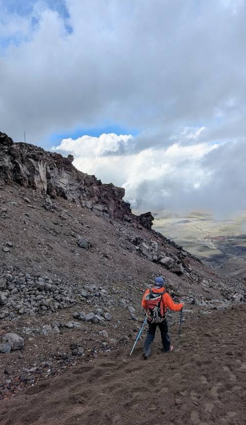       Rocky cliff overlooking a valley with a dusting of clouds.
  