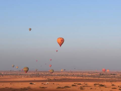 Hot air balloons over a desert landscape.