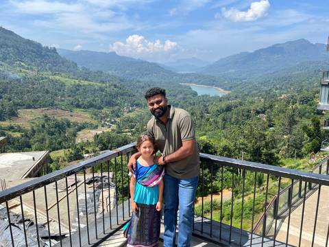 Man and child posing with mountain and lake view.