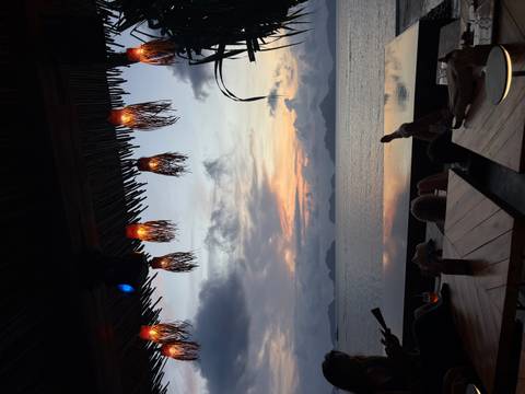       Sunset view over the sea with decorative hanging lights.
  