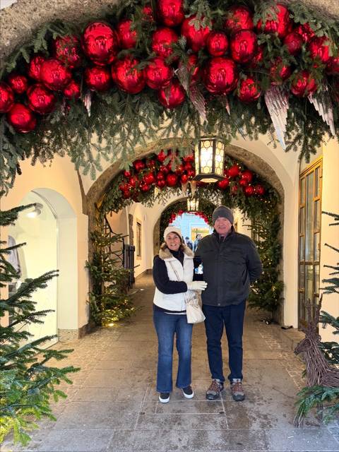       Couple in a decorated walkway during winter, festive decor.
  