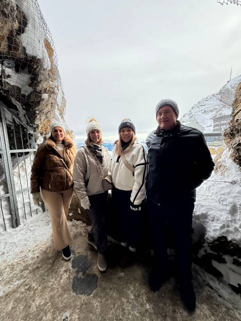       Family posing in front of snowy rock formations.
  
