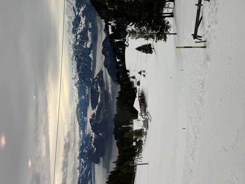       Snowy landscape with mountainous terrain in the distance.
  