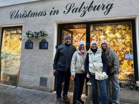       Group of people outside a decorated Christmas-themed store.
  