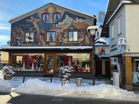       Street scene with traditional mural on a building wall.
  