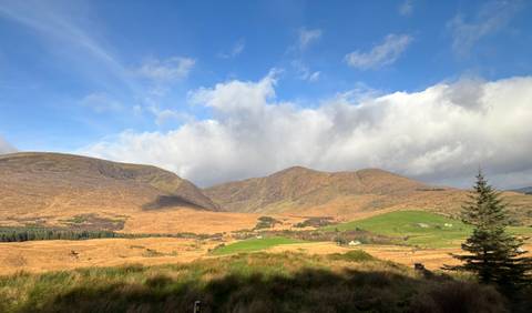 Landscape view of mountains under a blue sky with clouds.