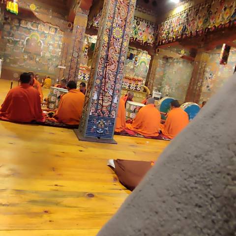 Monks seated in a decorated temple setting.