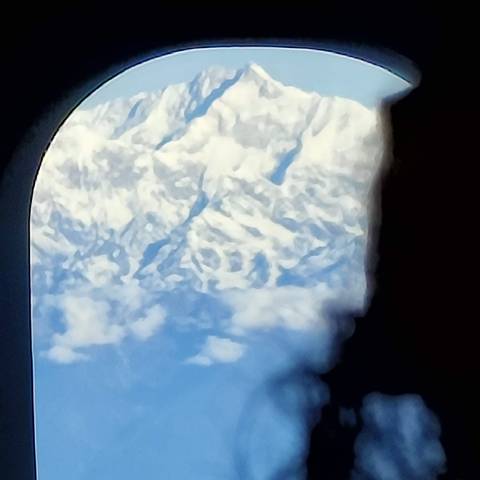 View from airplane window showing snow-covered landscape.