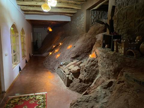 Interior with candles lighting a rocky wall.