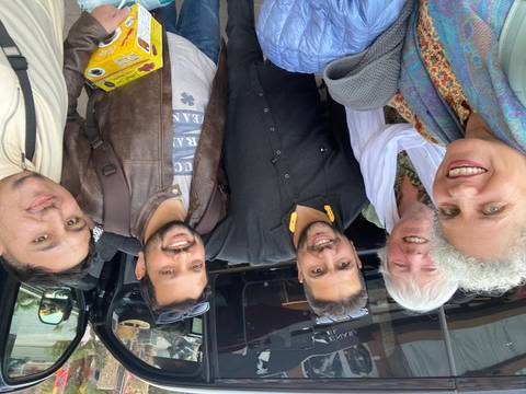 Group of friends smiling for a selfie outdoors.