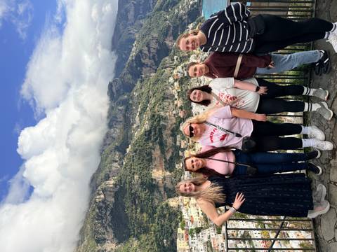 People posing with mountainous backdrop in Italy.