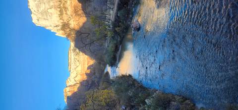 River running through a canyon under a clear blue sky.