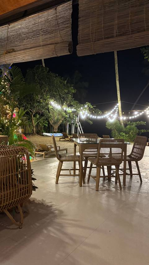 A nighttime outdoor setting with string lights and patio furniture.