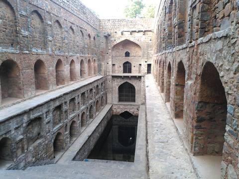 Historic stepwell with arches and corridors.