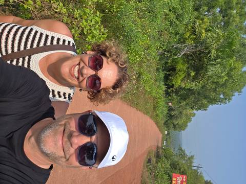 Close-up of two people smiling outdoors on a path.