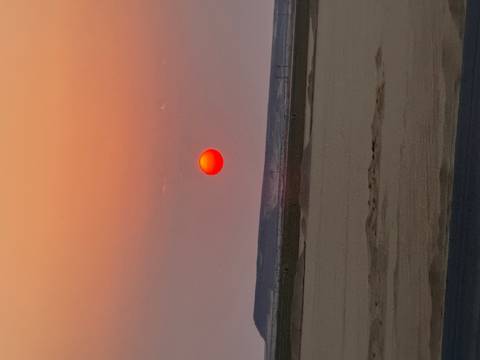 Desert landscape with the sun setting on the horizon.