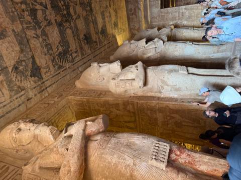 Tourists exploring ancient carvings of giant statues.