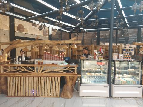       Outdoor cafe with people behind the counter.
  