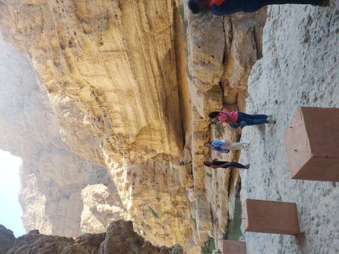       People exploring a rocky canyon.
  