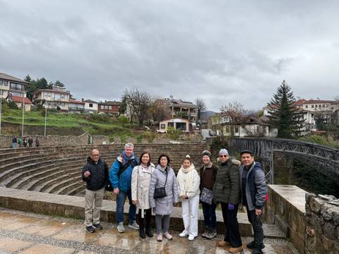       A group of people standing in front of an ancient amphitheater
  