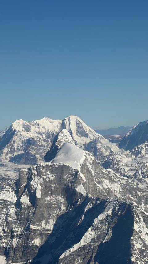       Panoramic view of snow-capped Himalayas under a clear blue sky.
  