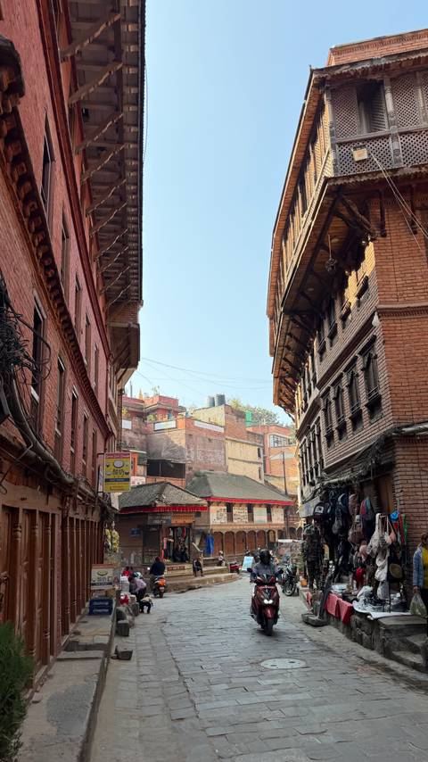       Narrow street with traditional brick buildings and intricate details.
  