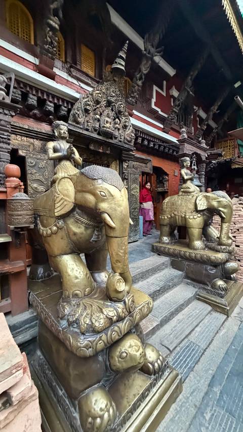       Golden elephant statues at the entrance of a traditional building.
  