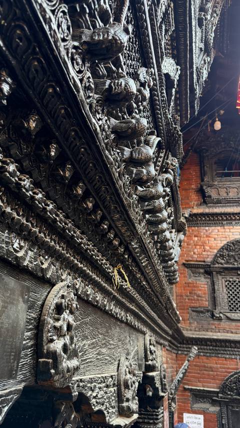       Close-up of intricate wooden carvings on a building.
  