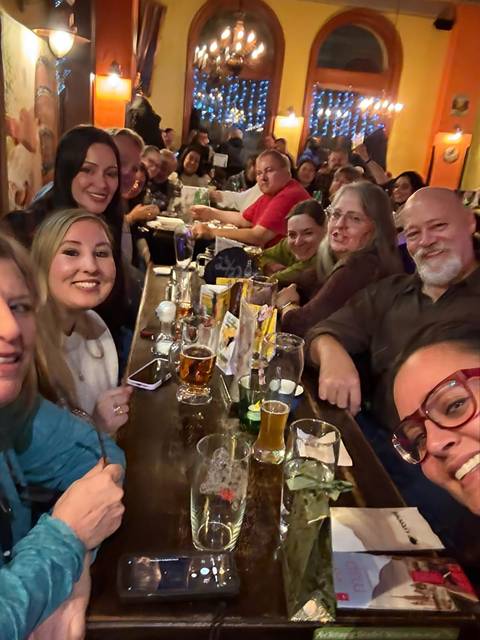       Group of people sitting at a bar with drinks enjoying a casual atmosphere.
  