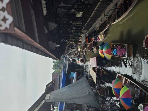 Bustling floating market with colorful umbrellas on boats.