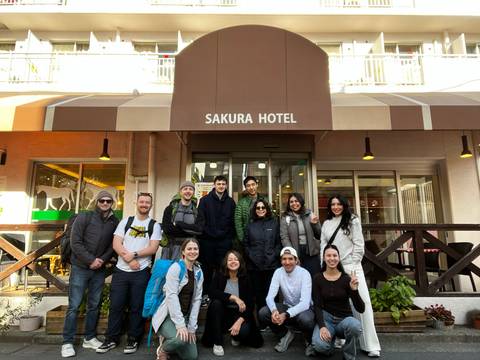 A group of people posing in front of the Sakura Hotel entrance.