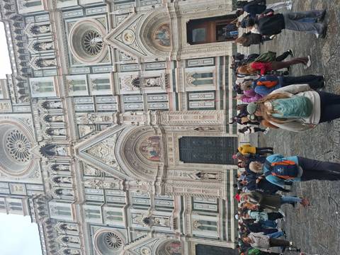 Crowd of tourists in front of a large cathedral facade.