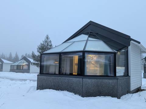 Modern glass-roofed cabins in a snowy environment.