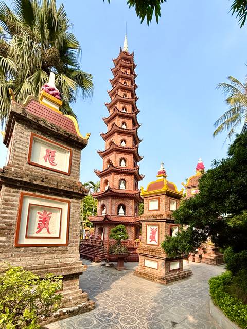 Pagoda with intricate designs in a garden setting.