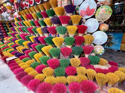 Colorful incense sticks and traditional Vietnamese hats on display.